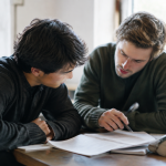 Hommes penches sur les textes assis ensemble